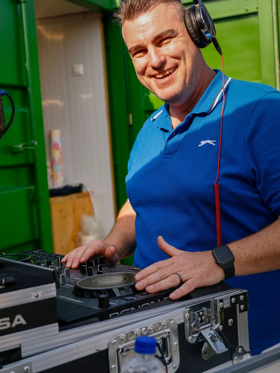 Adriaan van O-Ke Entertainment, lachend achter zijn Denon DJ-set tijdens een feest