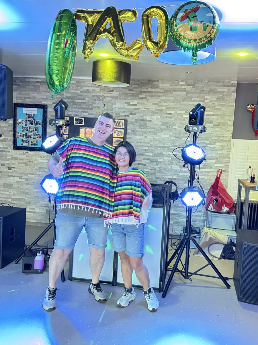Feestend duo in themakleding voor de lichtshow tijdens een 40e verjaardag met feest DJ